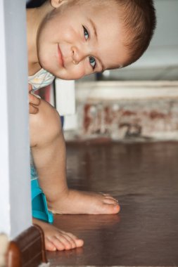 Küçük bir çocuk üzerinde pot oturuyor. 