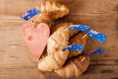 Taze kruvasan ve ahşap masa üzerine Avustralya bayrağı