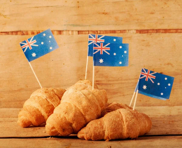Taze kruvasan ve ahşap masa üzerine Avustralya bayrağı