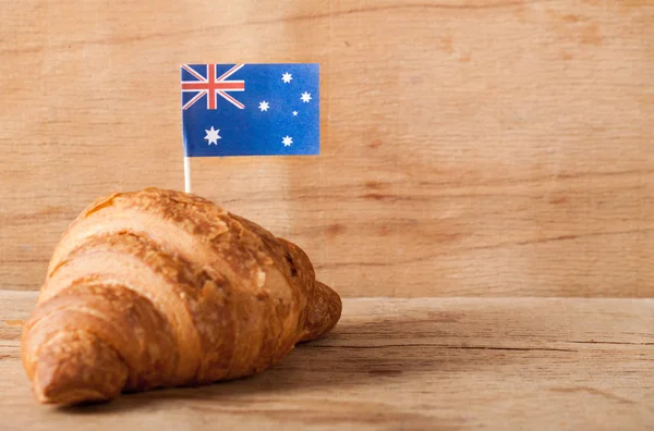 Taze kruvasan ve ahşap masa üzerine Avustralya bayrağı
