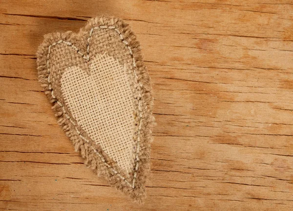 Coração feito de pano na mesa de madeira . — Fotografia de Stock