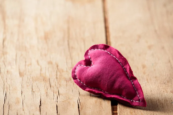 Heart from cloth on wood desk — Stock Photo, Image