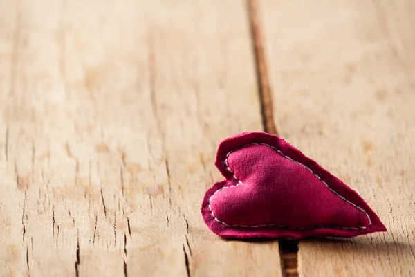 Heart from cloth on wood desk — Stock Photo, Image