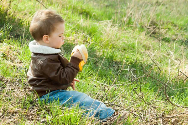Niño está comiendo un plátano — Foto de Stock