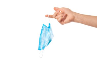 Tıbbi maske elinde.