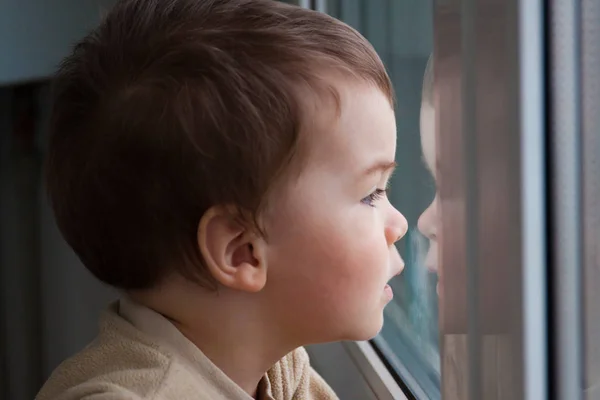 L'enfant regarde par la fenêtre — Photo