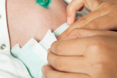 Anne bebek bezini değiştirir. 