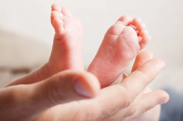 Pierna del bebé en la mano del padre —  Fotos de Stock