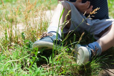 Bir çocuk çimlerde oturuyor