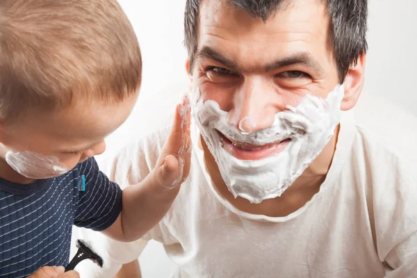 Papa bringt seinem Sohn bei, sich zu rasieren. — Stockfoto