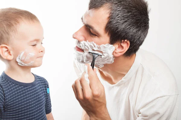 Тато вчить його син голити. — стокове фото