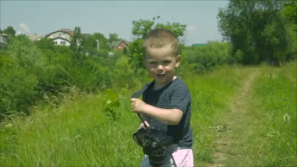 Ένα παιδί παίζει με μια φωτογραφική μηχανή — Αρχείο Βίντεο