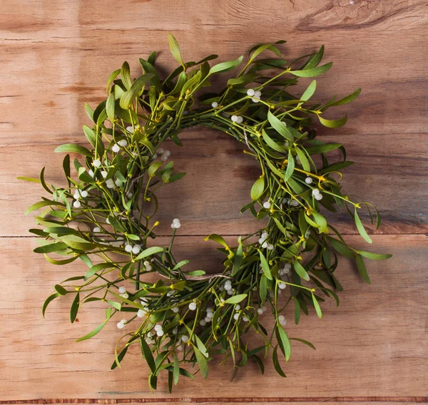 Ahşap tahta üzerinde ökseotu ile Noel çelenk. 