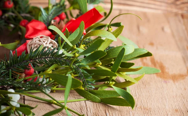 Corona de Navidad con muérdago sobre tabla de madera . — Foto de Stock