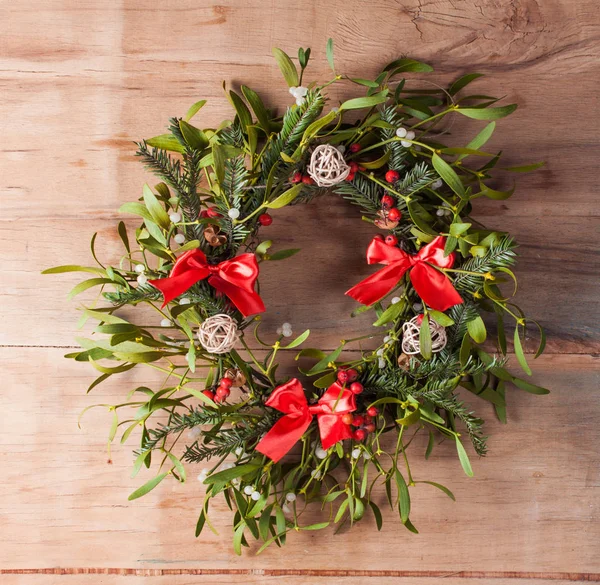 Ahşap tahta üzerinde ökseotu ile Noel çelenk. 