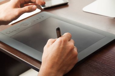 Grafik tasarımcı bir tablete çizer