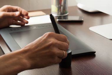 Grafik tasarımcı bir tablete çizer