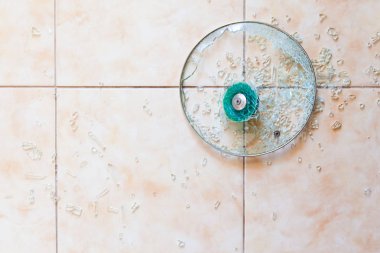 Yerdeki kırık cam kapak.