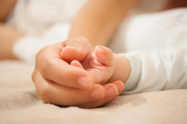 Mamma håller babyns hand. — Stockfoto