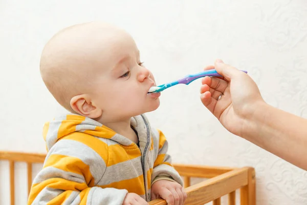 Il bambino mangia il porridge con un cucchiaio — Foto Stock