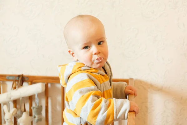 Barnet äter gröt med en sked — Stockfoto