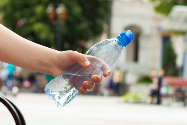 Человек держит бутылку с водой
