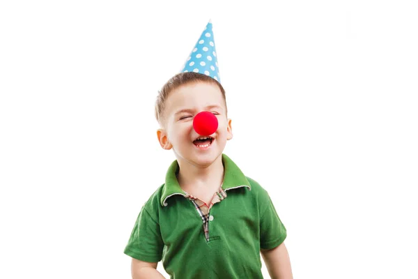 Niño en un cono festivo y la nariz de un payaso — Foto de Stock