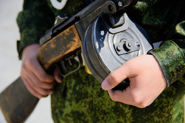 The submachine gun Shpagin in the hands of a soldier close-up with a selective focus with a shallow depth of field