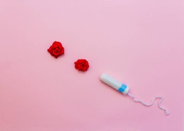 Pembe arka planda bir tampon. Kanlı kadın şeridi. Kadınların kritik günleri