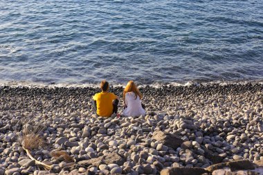 Okyanusun arka planında oturan insanların figürleri. Tenerife, Kanarya Adaları, İspanya