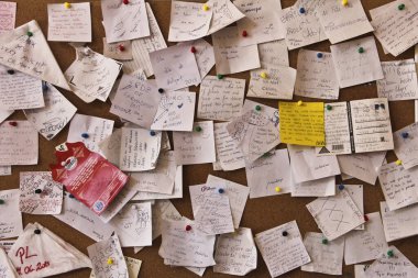 Duvara kaotik bir şekilde yapıştırılmış post-it notları. Yoğun bir kavram. Kelimenin farklı dillerinde