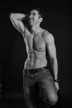 Siyah beyaz stüdyo çekimlerinde güçlü atletik adam karanlık arka planda. seksi vücut