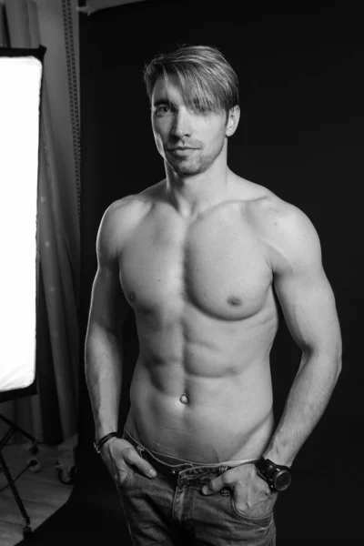 Zwart-wit studio shoot van sterke atletische man op donkere achtergrond — Stockfoto