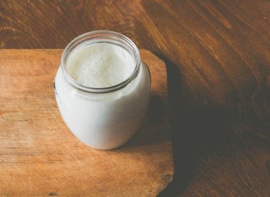 Ahşap bir gemide bir cam kap içinde ekşi süt