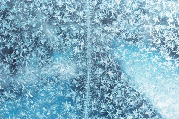 Frost mönster på ett fönster. Bakgrundsfoto Stockbild