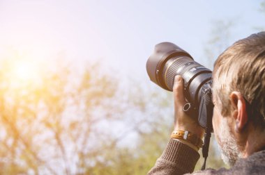 Fotoğrafçı telefoto lens ile fotoğraf makinesi ile. Çekim uzak nesneleri