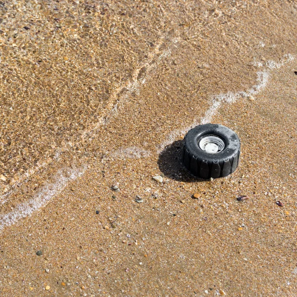 海岸で砂海のグッズからプラスチック製のホイール — ストック写真
