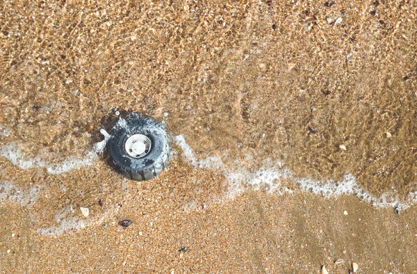 海岸で砂海のグッズからプラスチック製のホイール — ストック写真