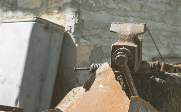 Old iron vice among tools for work fixed on a log — Stock Photo, Image