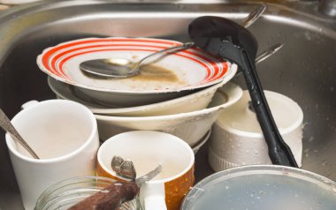 Kirli yıkanmamış mutfak gereçleri ve lavaboda yemekleri