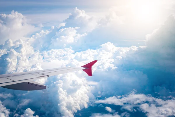 Ciel nuageux et aile de l'avion rouge vu à travers la fenêtre sur aircr — Photo