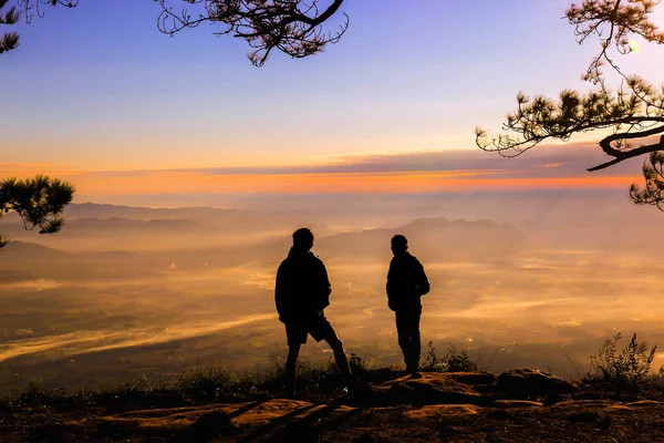 Silluate tow man raise hand up and standing during sunset on top — Stock Photo, Image