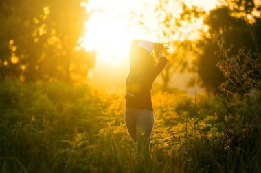 Günbatımı veya gündoğumu açık havada doğa yaz zevk kamera ile güzel bir genç kadın gezgin portresi görünüyor