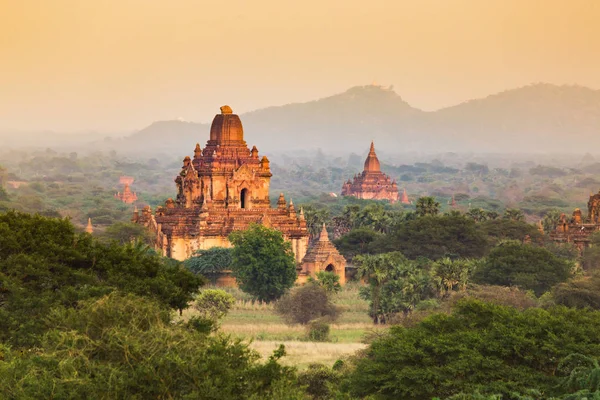 Nascer do sol com templo antigo e paisagem verde, Bagan, Myanmar — Fotografia de Stock