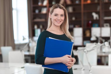 İş kadını elinde bir klasörle ofisinde mi