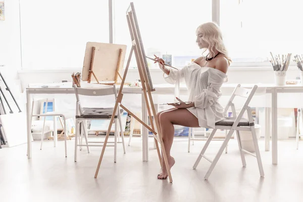 Schöne Frau malt auf Leinwand — Stockfoto