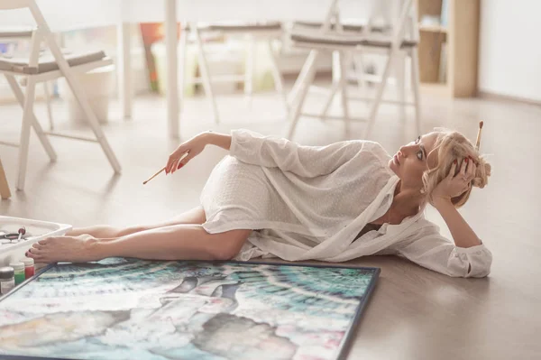 Sanatçı stüdyoda yatıyor ve bir poz vardır