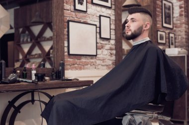 berber bir sandalyede oturan bir genç adam