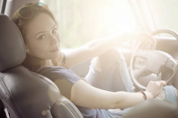 Kız bir arabanın direksiyonuna oturur