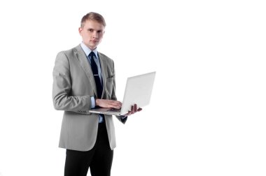 Elinde beyaz izole arka plan üzerinde duran ve bakıyorsun dizüstü bilgisayar ile genç işadamı